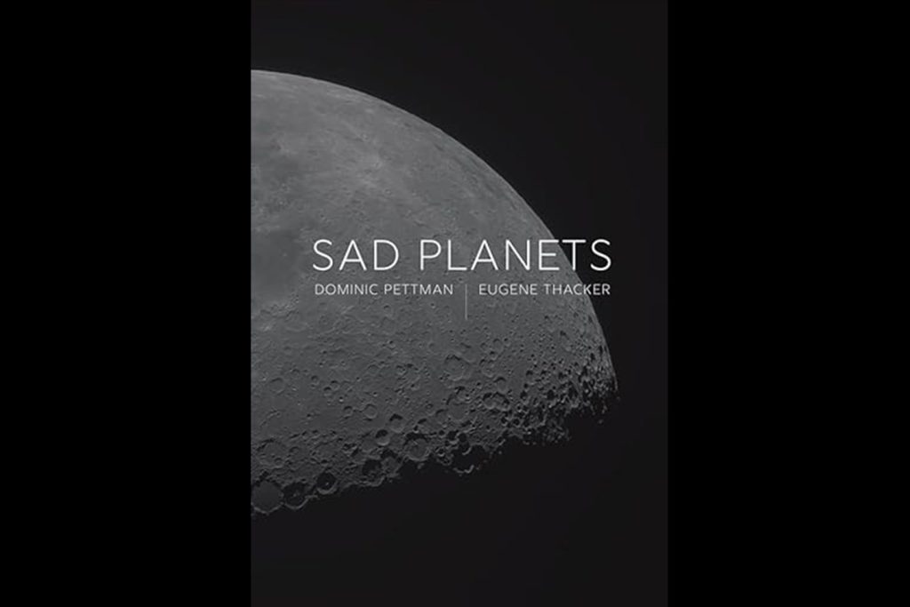 Cover of Dominic Pettman and Eugene Thacker's book: photo of a quarter of a grey planet in shadow against a black background